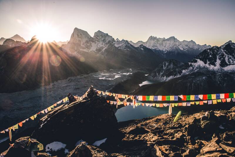 Gipfelregion im Himalaya mit untergehender Sonne und einer bunten Wimpelkette