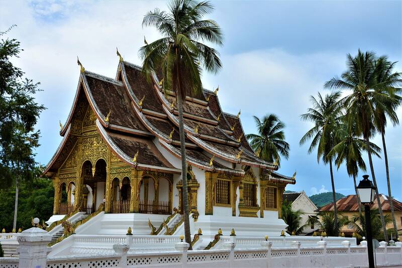 Tempel von Luang Prabang in Laos, im Vordergrund Palmen